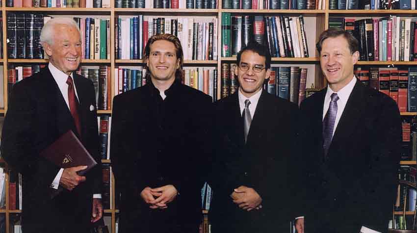 Bob Barker stands in front of a bookshelf at Harvard Law School with Chris Green and others