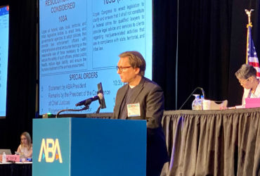 Chris Green speaks to the ABA House of Delegates from the podium.