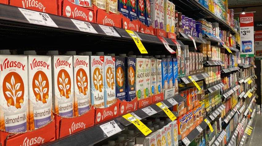 A supermarket shelf full of plant-based milks